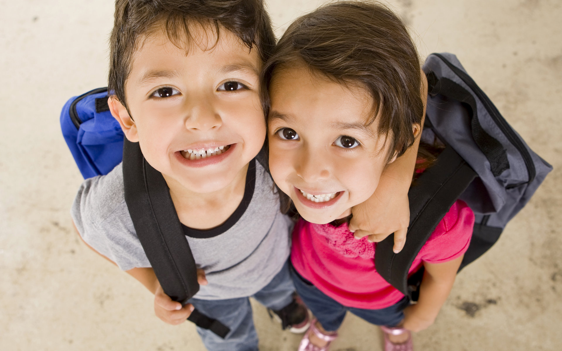 Two cheerful little boys showing teeth in their smiles.